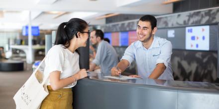 Young man behind the counter talking to a student