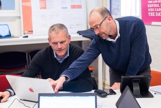 2 men looking at a computer