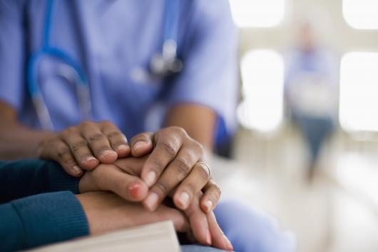 holding hands with a nursing uniform in the background