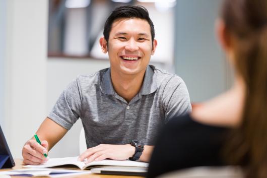 Student smiling with a book