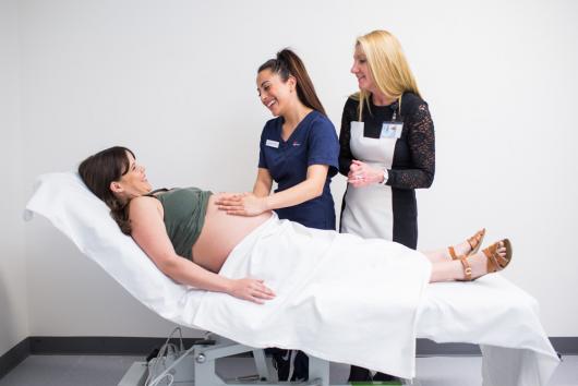 CUA midwifery student examines a pregnant woman