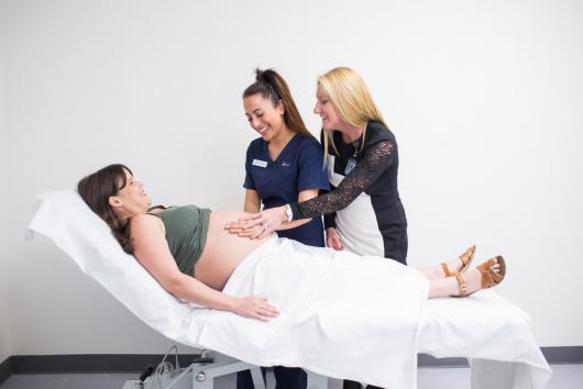 Pregnant lady being examined by CUA midwifery student