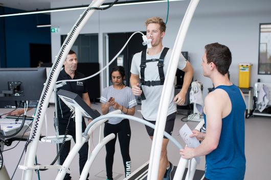 An athlete on a treadmill being examined by researchers