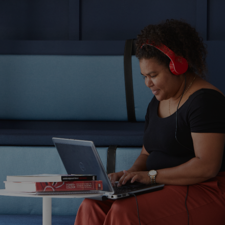 Girl with red headphones looking at her laptop