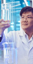 Scientist holding a beaker and working in lab