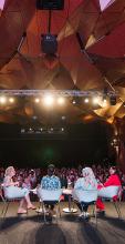 Onstage at a WMN panel discussion with a big crowd in the CUA Great Hall