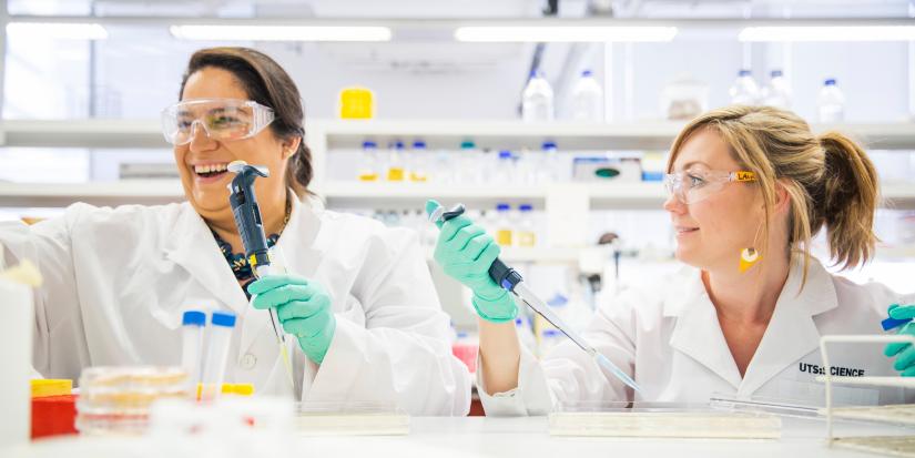 two researchers in a lab laughing